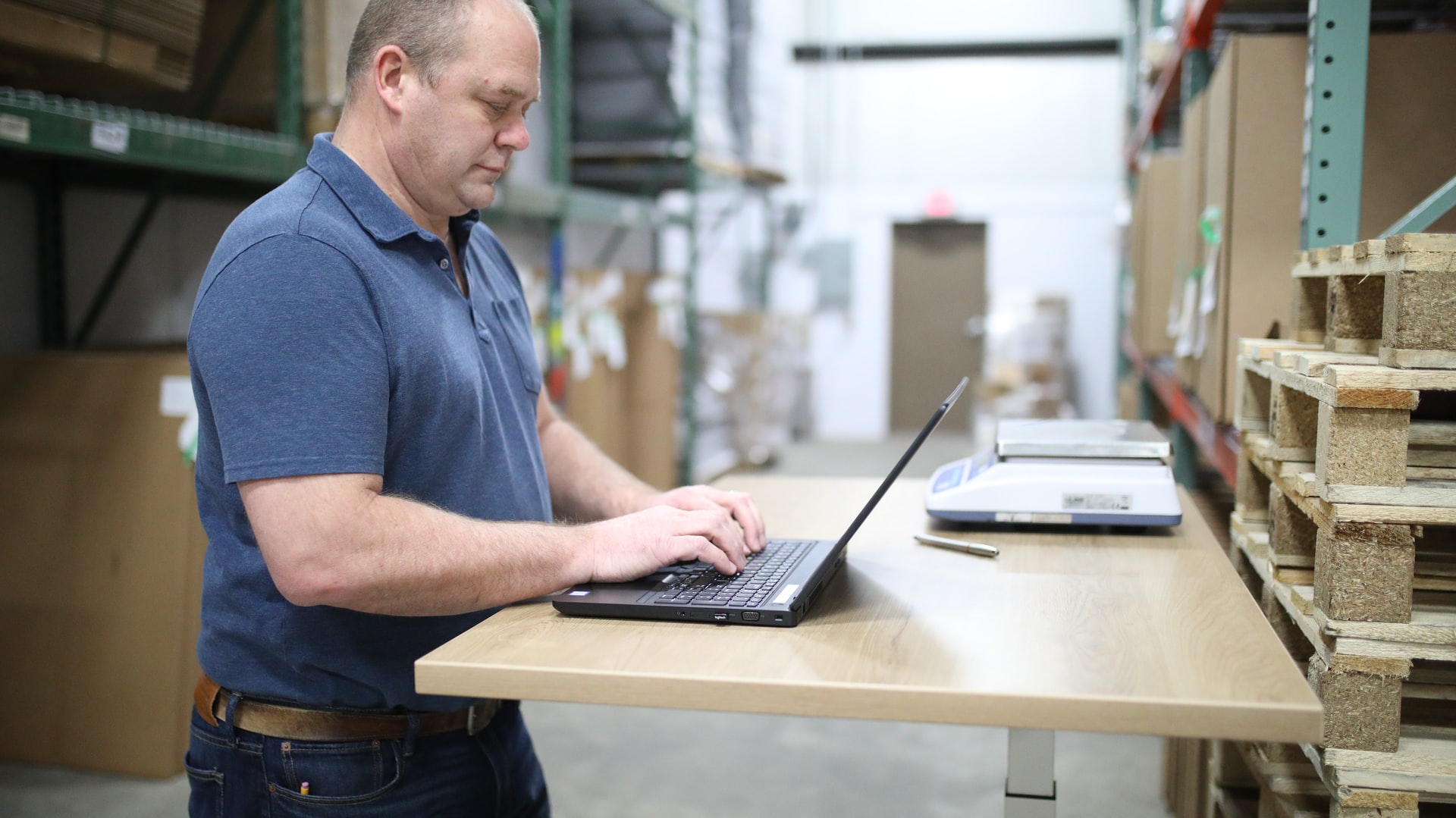 man in blue polo shirt using laptop computer